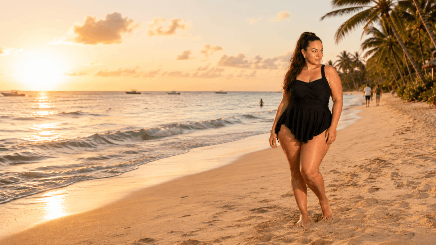 BloomChic Swim Dress Reviews: 17 Styles Compared for Fit, Support and Coverage 2 Plus-size woman wearing a black swim dress on a beach at sunset